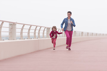 Image showing mother and cute little girl on the promenade by the sea