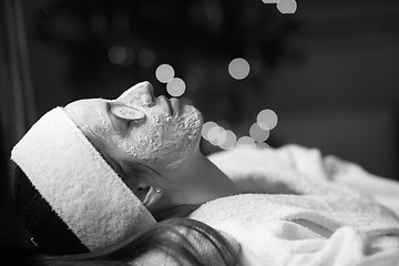 Image showing woman is getting facial clay mask at spa