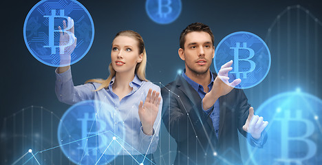 Image showing businessman and businesswoman with bitcoins