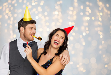 Image showing happy couple with party blowers having fun