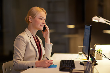 Image showing businesswoman calling on sartphone at night office