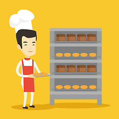 Image showing Happy young male baker holding tray of bread.