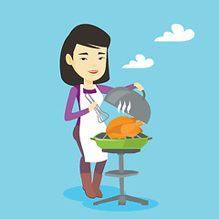 Image showing Woman cooking chicken on barbecue grill.