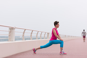 Image showing woman stretching and warming up on the promenade