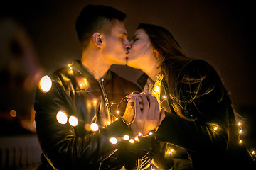 Image showing Young couple kissing and hugging outdoor in night street at chri