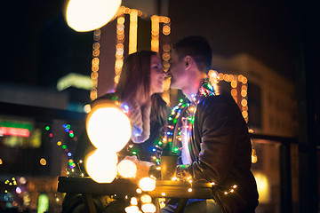 Image showing Young couple kissing and hugging outdoor in night street at christmas time