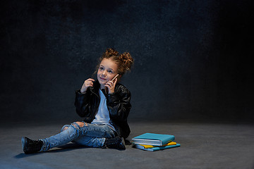 Image showing Little girl sitting with smartphone in studio
