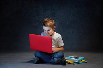 Image showing Little boy sitting with laptop in studio