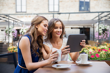 Image showing young women with tablet pc drinking coffee at cafe