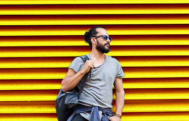 Image showing man in sunglasses with bag standing at street wall