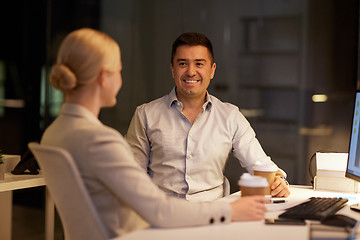 Image showing business people drinking coffee at night office