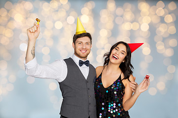 Image showing happy couple with party blowers having fun