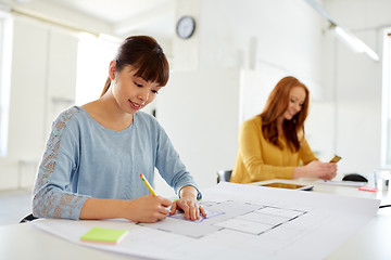 Image showing female architect with blueprint working at office