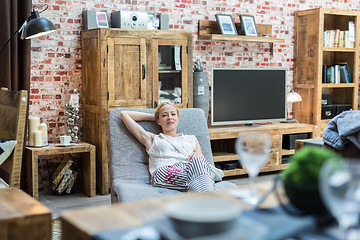 Image showing Woman shopping for new rocking chair in furniture store.