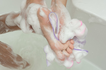 Image showing Mom washes the child\'s feet with a washcloth and soap