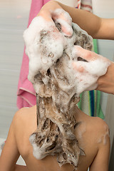 Image showing Mom massages his head with soaping baby hair shampoo