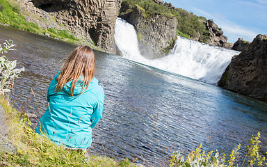 Image showing Woman sitting at a waterfall