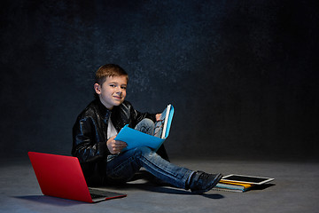 Image showing Little boy sitting with gadgets