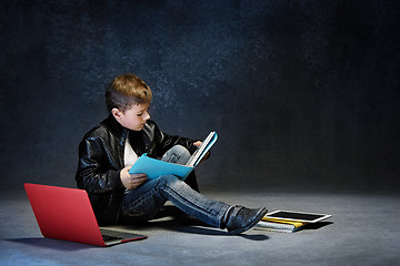 Image showing Little boy sitting with gadgets
