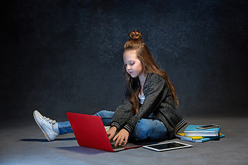 Image showing Little girl sitting with gadgets