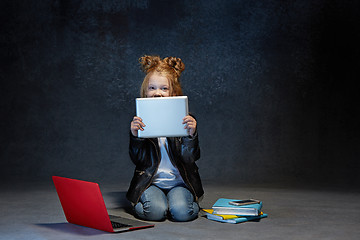 Image showing Little girl sitting with gadgets