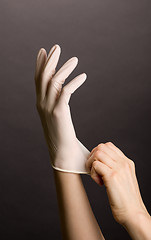 Image showing Putting on latex gloves