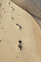 Image showing Nature background with sea water and footprints in the sand 