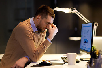 Image showing tired businessman working at night office