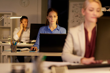 Image showing businesswoman at computer working at night office