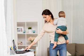 Image showing mother with baby and laptop working at home