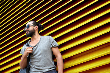 Image showing man in sunglasses with bag standing at street wall