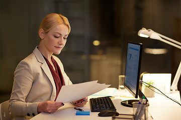 Image showing businesswoman with papers working at night office