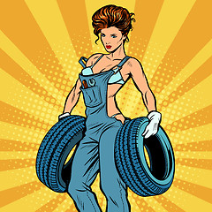 Image showing woman in overalls with tires, car service