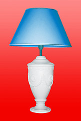Image showing Vintage table lamp iwith a blue eyeshadow on red background