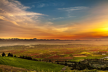 Image showing Beutiful sunset over colored agricultiral fields