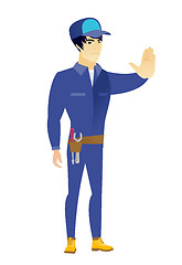 Image showing Asian mechanic showing stop hand gesture.
