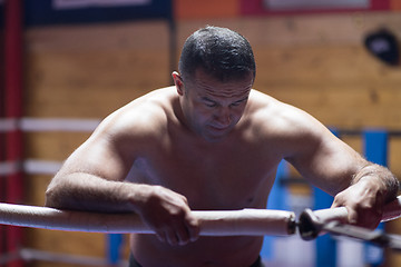 Image showing kick boxer resting on the ropes in the corner