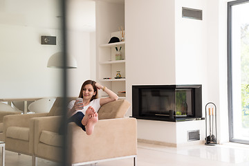 Image showing woman sitting on sofa with mobile phone