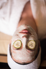 Image showing woman is getting facial clay mask at spa