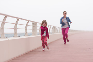 Image showing mother and cute little girl on the promenade by the sea