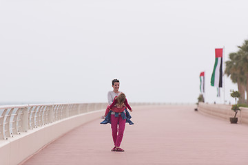 Image showing mother and cute little girl on the promenade by the sea