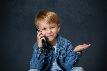 Image showing Little boy sitting with smartphone in studio