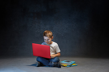 Image showing Little boy sitting with laptop in studio