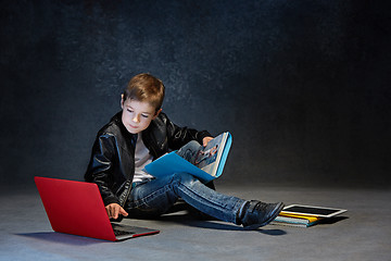 Image showing Little boy sitting with gadgets