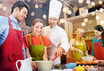 Image showing happy friends and chef cook baking in kitchen