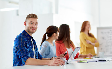 Image showing happy man with creative team at office conference