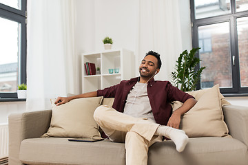 Image showing man in earphones with tablet pc listening to music