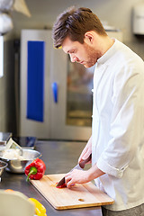 Image showing happy male chef cooking food at restaurant kitchen