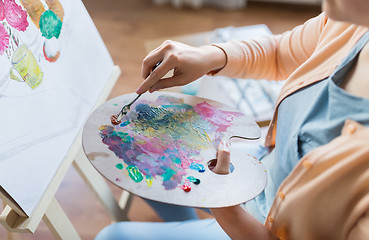 Image showing artist with palette knife painting at art studio