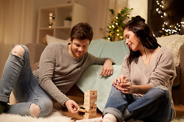 Image showing happy couple playing block-stacking game at home